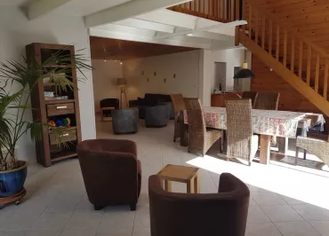 Grand salon/salle à manger avec escalier en bois menant à l'étage