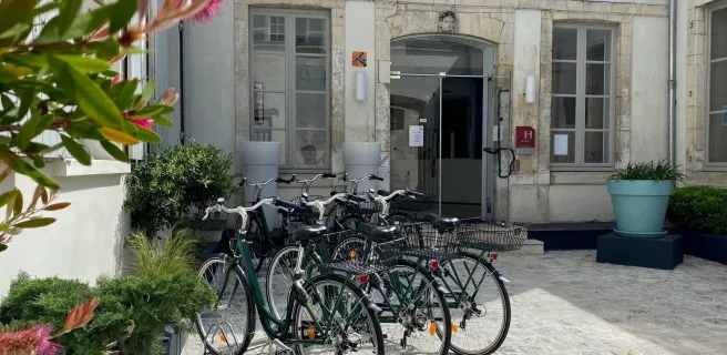 La cour de l'entrée de l'hôtel, 3 vélos sont garés devant.