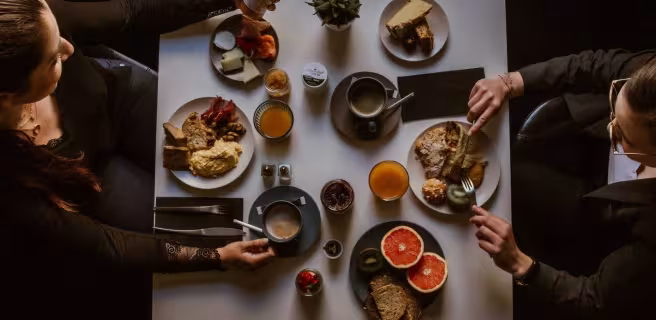 Deux femmes vues de dessus, en train de prendre un petit-déjeuner varié.